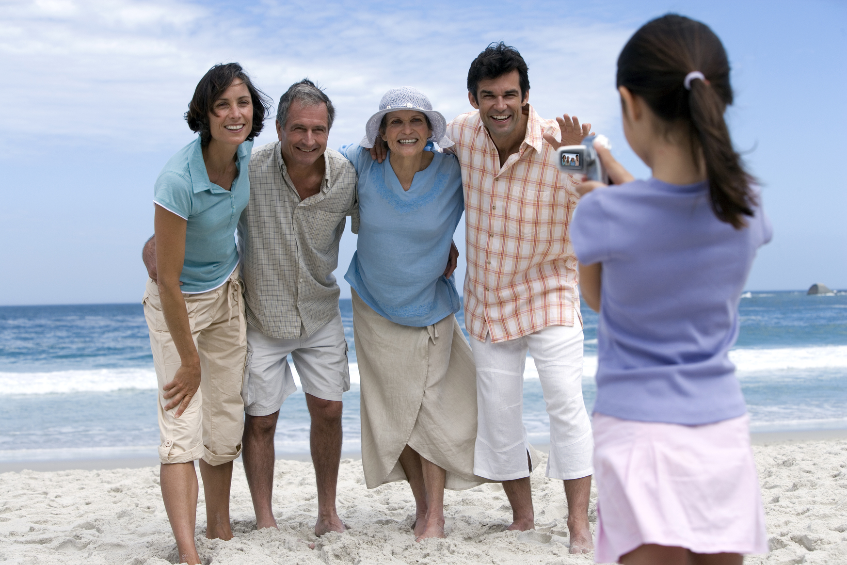 Multigenerational family taking a video on the beach